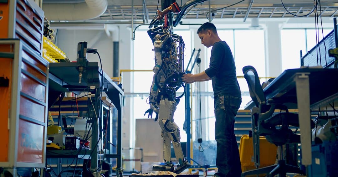 A mechanical engineer works on an Atlas robot.