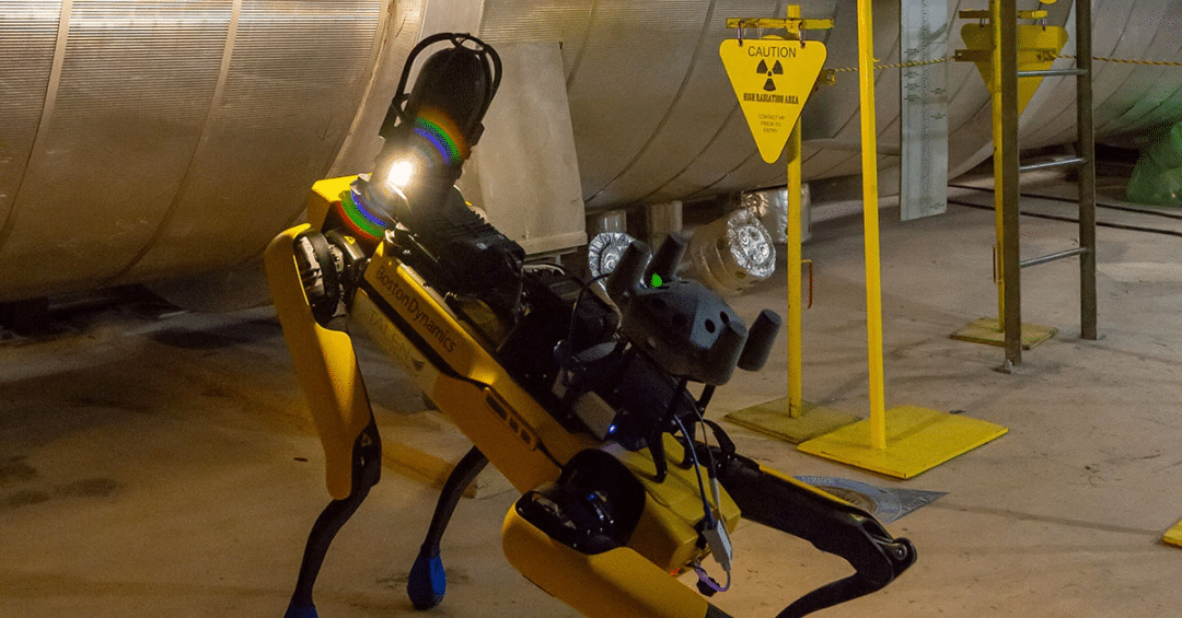 Spot performs in inspection in front of a nuclear hazard sign