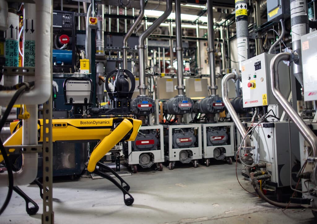 Spot in a semiconductor fab inspecting a row of industrial equipment