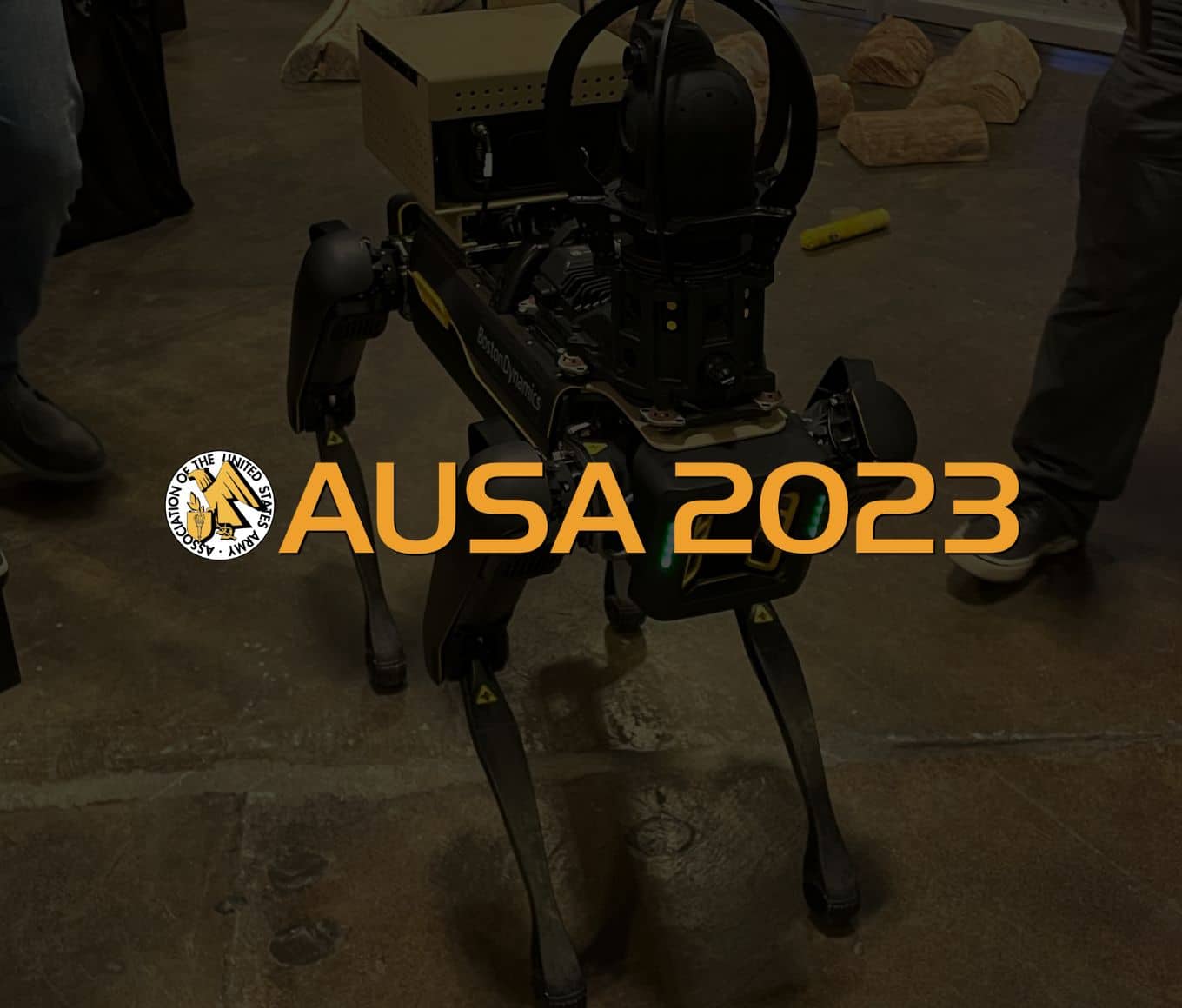 a dark-colored Spot in a trade show booth with the AUSA 2023 logo overlaid