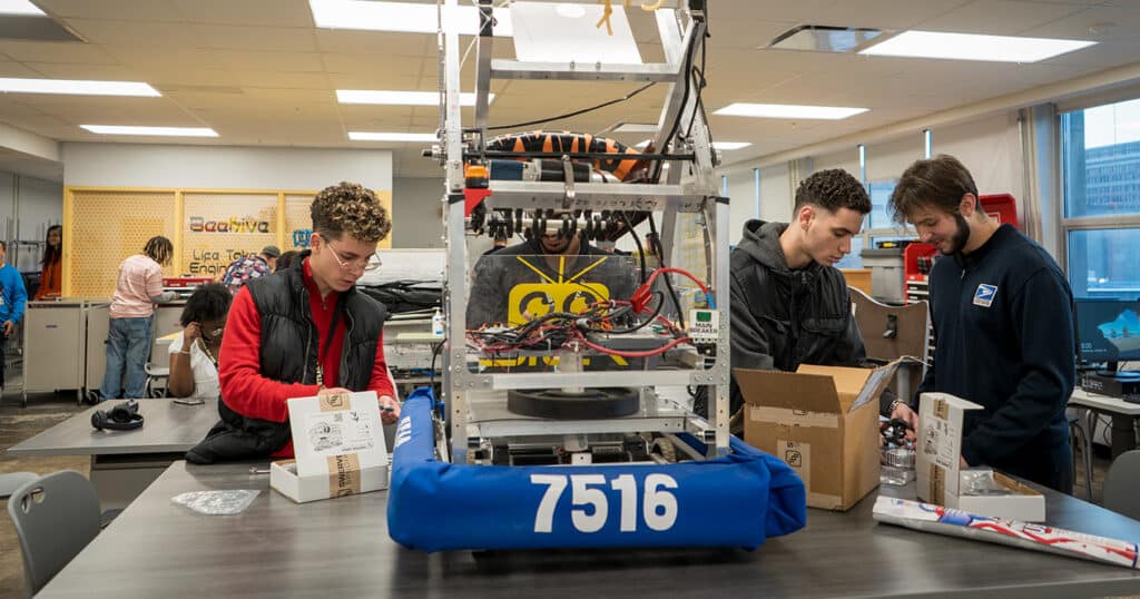 CHS students work on a large robot in a  technical lab