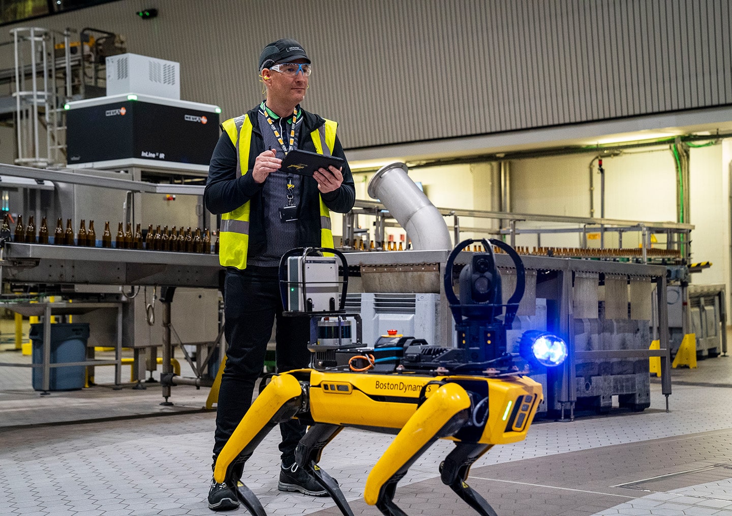 An operator in a hi-vis vest uses the tablet controller to create an autonomous inspection route in a brewery