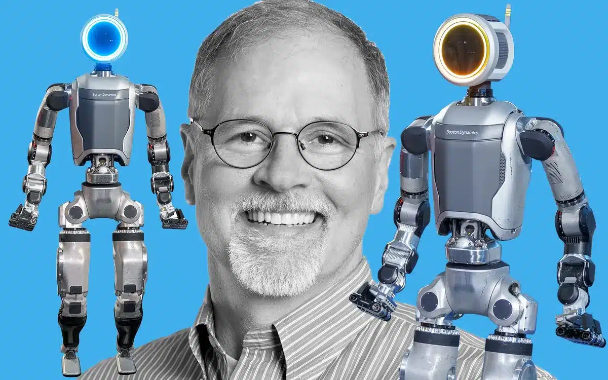 A headshot of Robert Playter, between two humnaoid robots