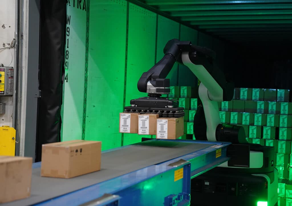 A Stretch robot unloads three cases to a conveyor