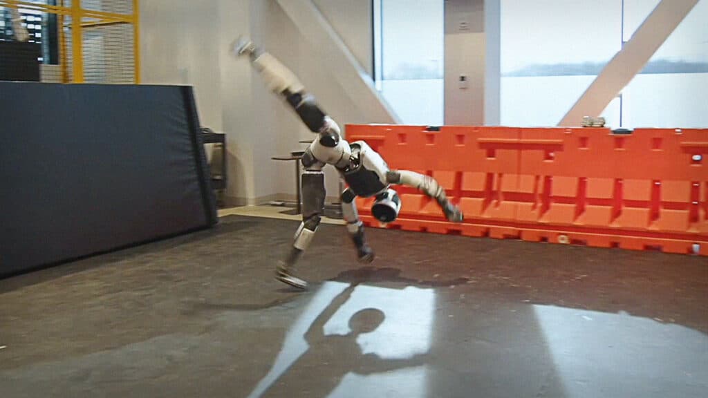 The Atlas humanoid robot is mid-way through a cartwheel in a robotics lab.