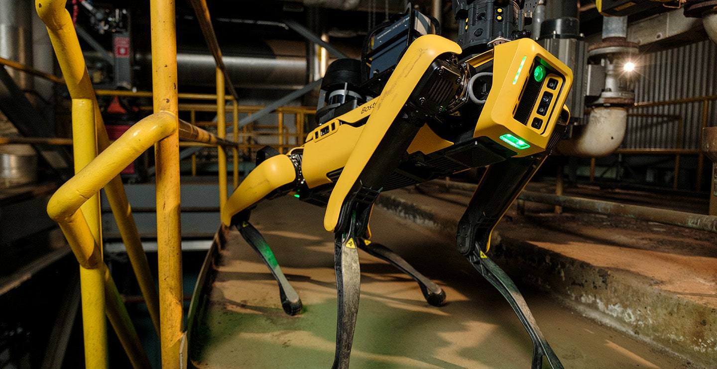 A spot robot poses to collect viual data in an industrial facility