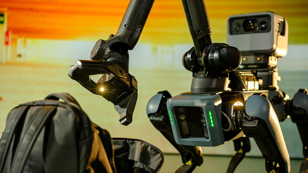 A spot robot chacks a suspicious package with its arm