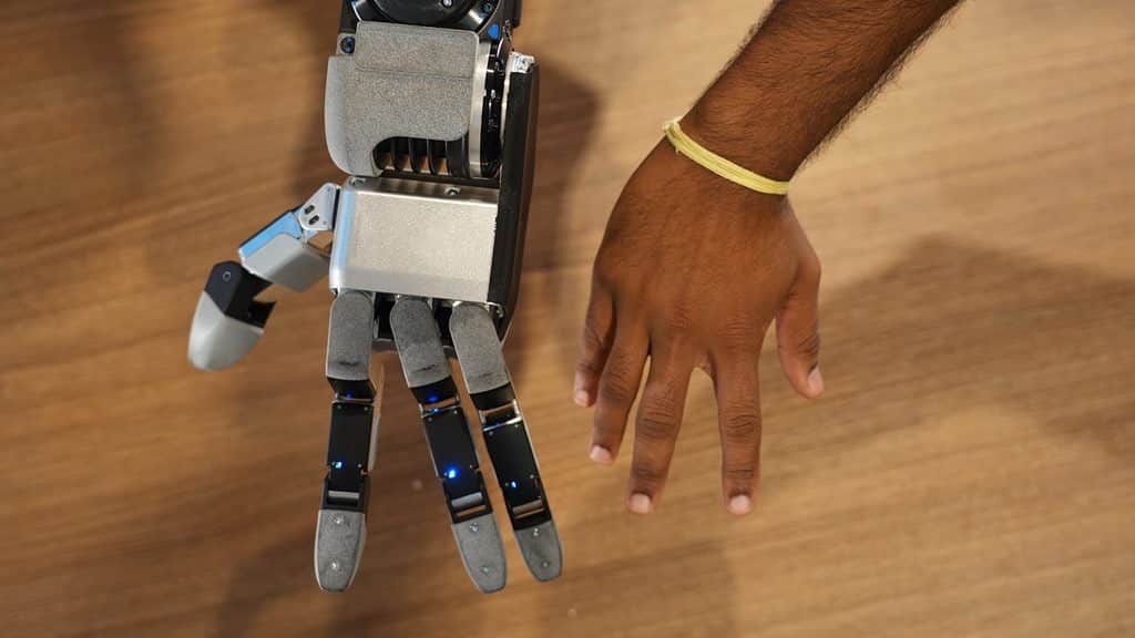 A side-by-side comparison of the new Atlas hand and a person's hand